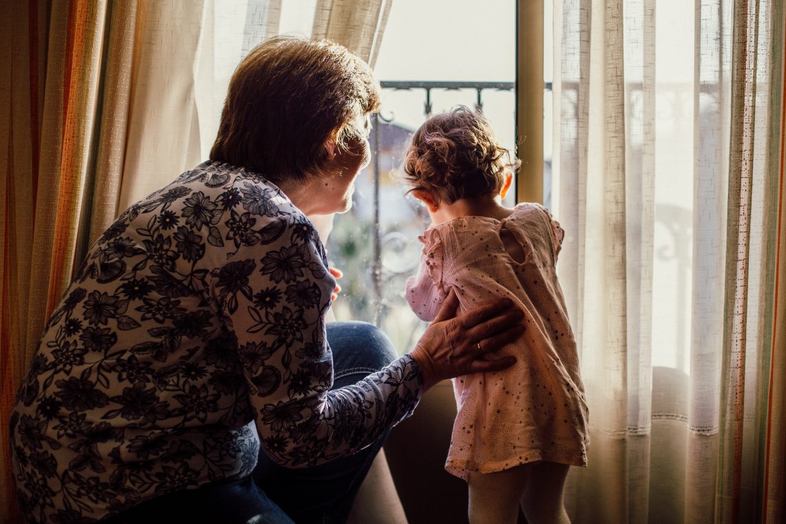 grandmother and grandchild looking out of window