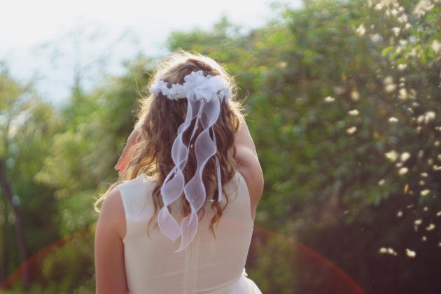 ung pige i hvid kjole med krøllet hår