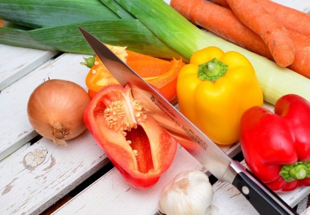 Grøntsager, løg, peberfrugter og en køkkenkniv